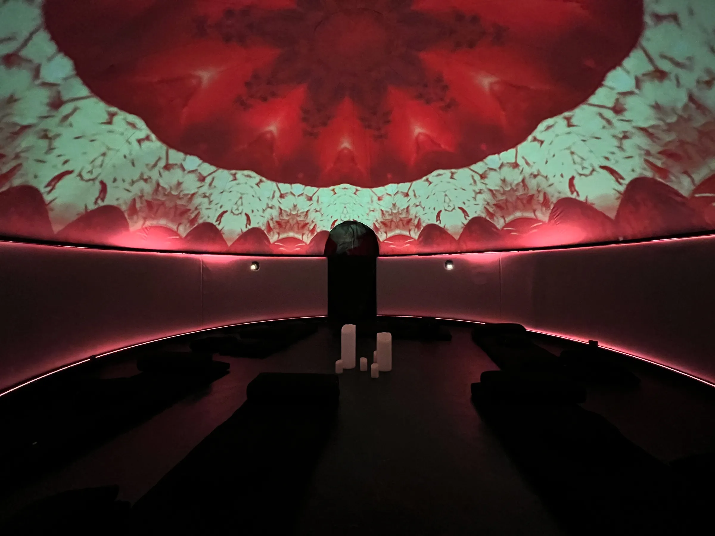 The Sensorium dome bathed in deep red, candlelit - the IGNITE program environment